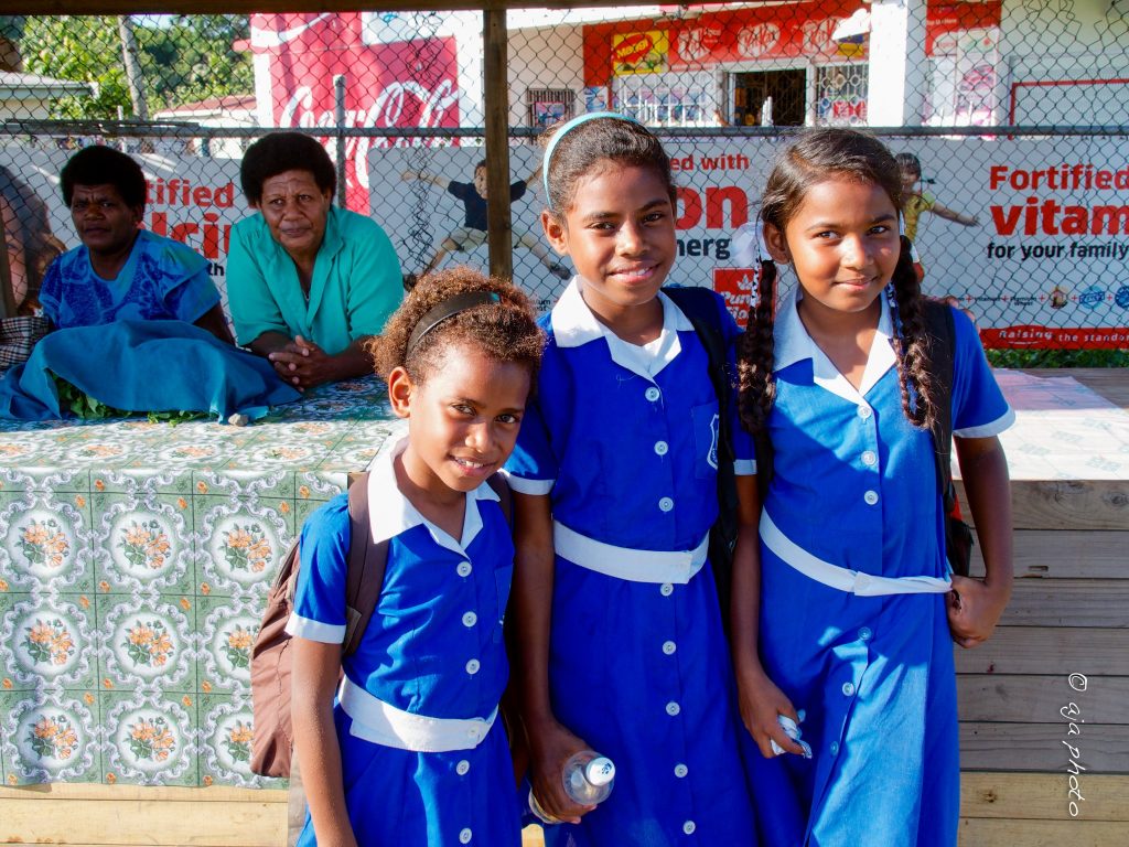 Three school children heading to school -- education is a valued component of Fiji culture