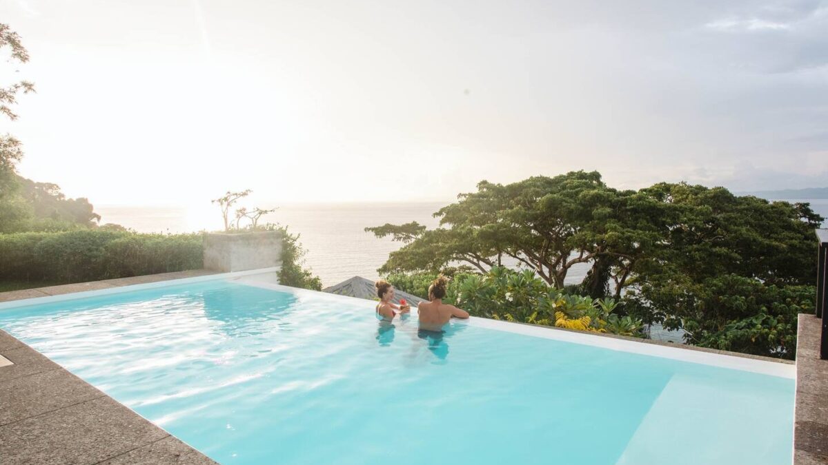 Couple relaxing in the infinity pool at Tavola Villa overlooking Savusavu Bay, Fiji